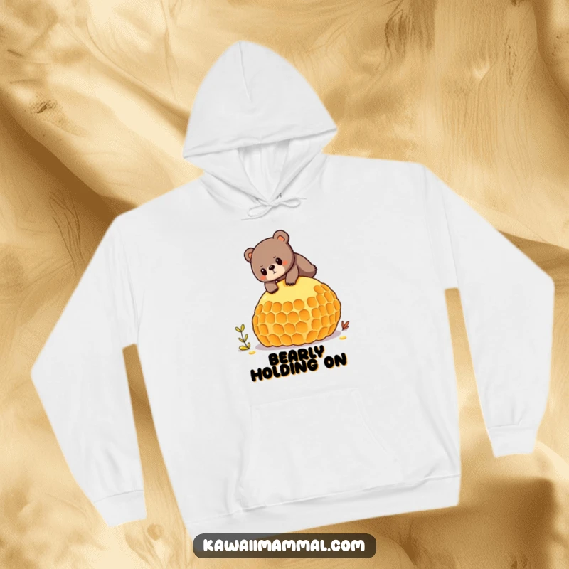 Funny hoodie showcasing a determined bear character balancing on a giant honeycomb, perfect for cozy and humorous wear.