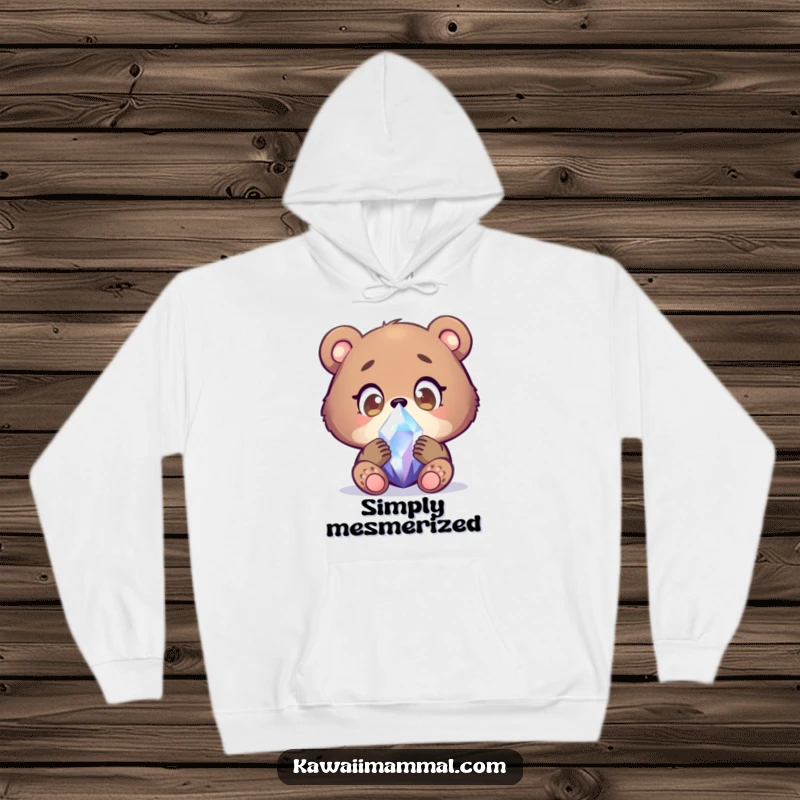 Funny bear cub hoodie with a focused character examining a shimmering crystal with wide, wondering eyes, offering cozy comfort and a sense of wonder.